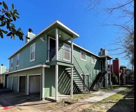an empty room with wooden floor fireplace and windows