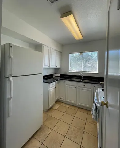 an empty room with wooden floor and chandelier