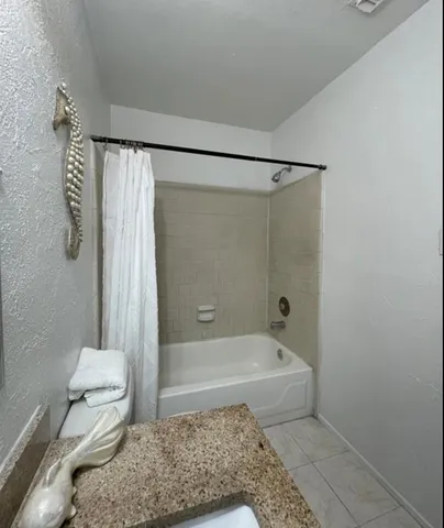 a bedroom with a bed lamp closet and three large window