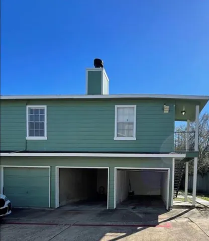an empty room with wooden floor fireplace and windows