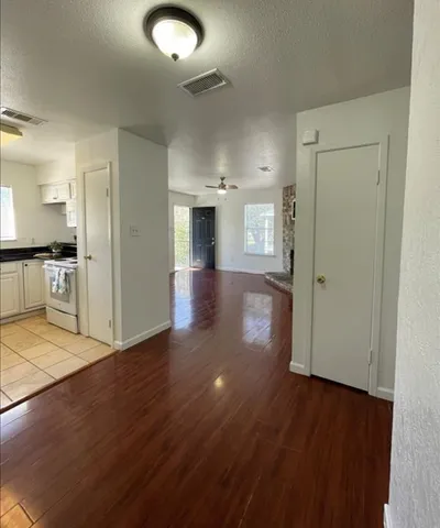 a kitchen with granite countertop white cabinets white appliances with a sink and a window