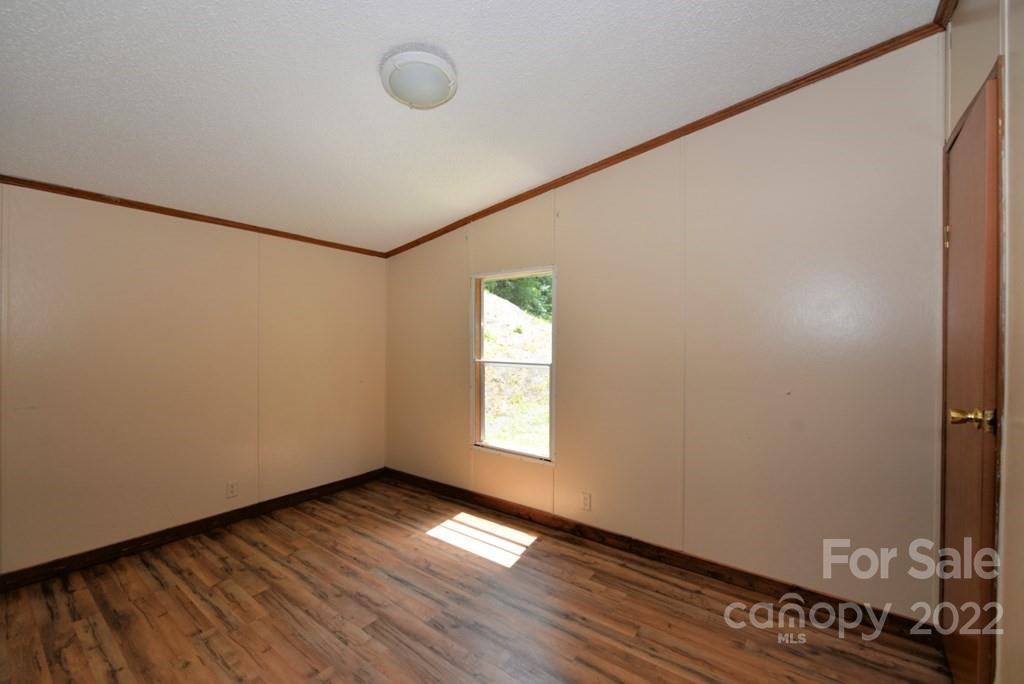 280 Lightning Bug Lane Waynesville, NC 28786 - Photo 11 of 26 a view of empty room with wooden floor and fan