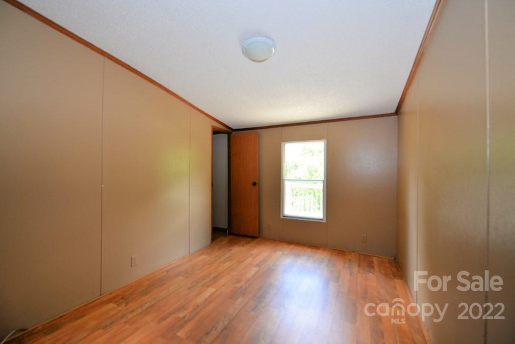 280 Lightning Bug Lane Waynesville, NC 28786 - Photo 13 of 26 a view of an empty room with wooden floor and a window