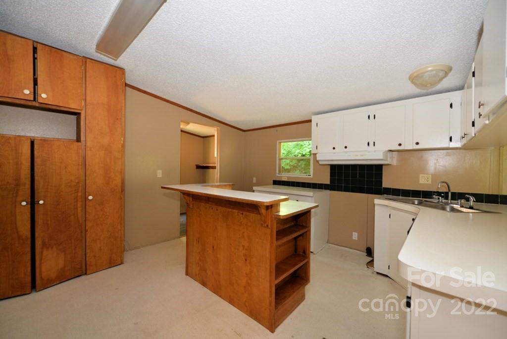 280 Lightning Bug Lane Waynesville, NC 28786 - Photo 21 of 26 a kitchen with stainless steel appliances a stove top oven a sink a refrigerator and white cabinets