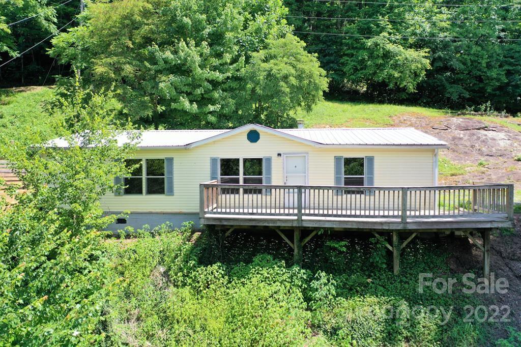 280 Lightning Bug Lane Waynesville, NC 28786 - Photo 6 of 26 a view of a white house with a yard and sitting area