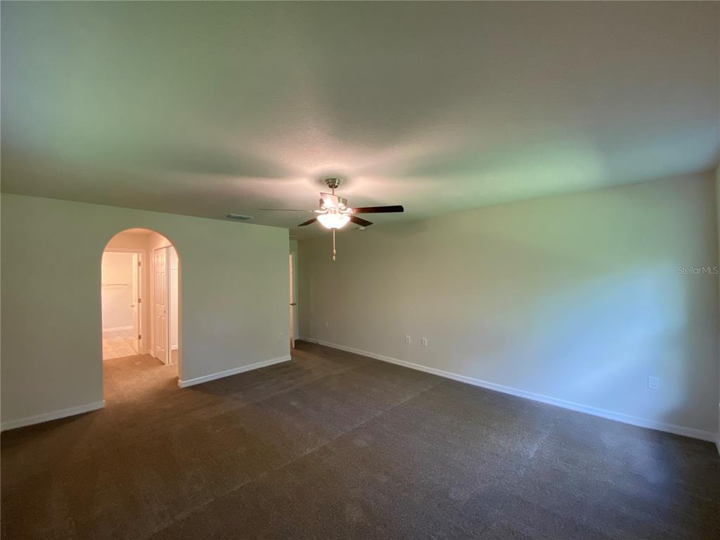 16090 Southwest 55th Avenue Road Ocala, FL 34473 - Photo 15 of 28 an empty room with a empty space and a ceiling fan