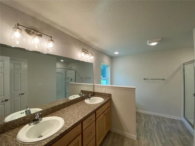 a bathroom with a granite countertop sink a mirror and a toilet
