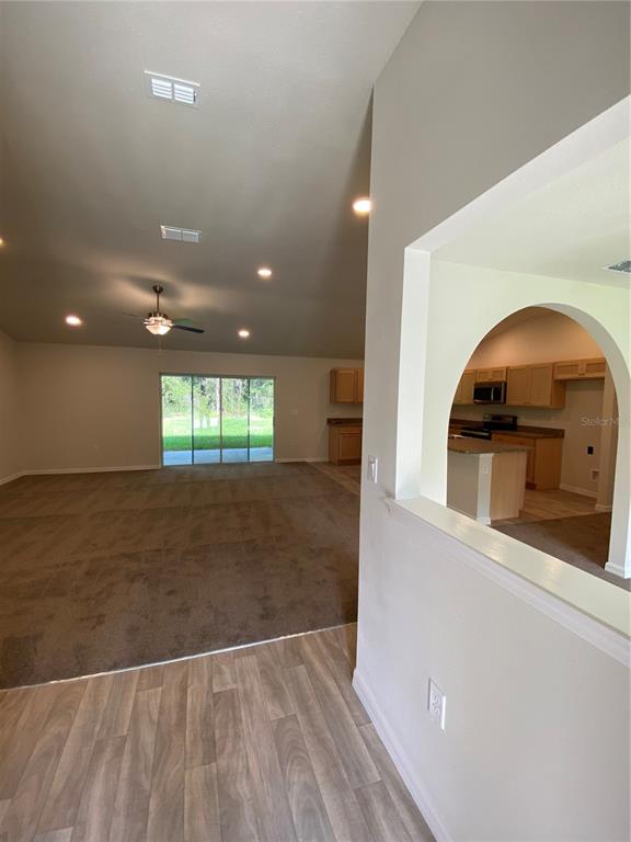 16090 Southwest 55th Avenue Road Ocala, FL 34473 - Photo 3 of 28 an empty room with wooden floor and entryway