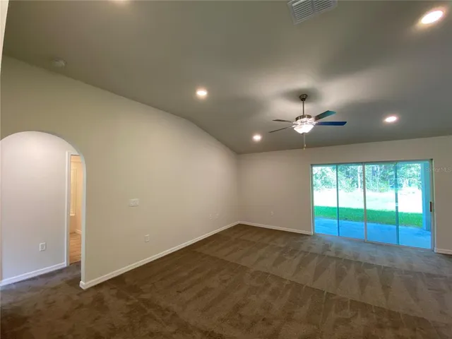 an empty room with a ceiling fan and window