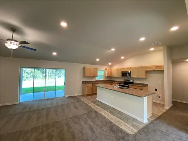 a kitchen with stainless steel appliances kitchen island granite countertop a stove and a sink