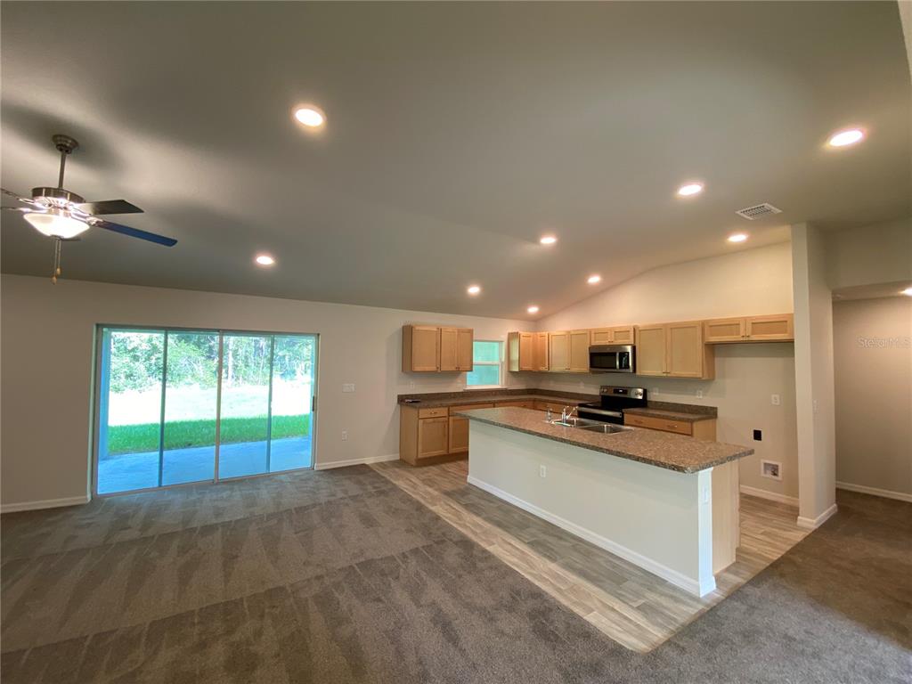 16090 Southwest 55th Avenue Road Ocala, FL 34473 - Photo 5 of 28 a kitchen with stainless steel appliances kitchen island granite countertop a stove and a sink