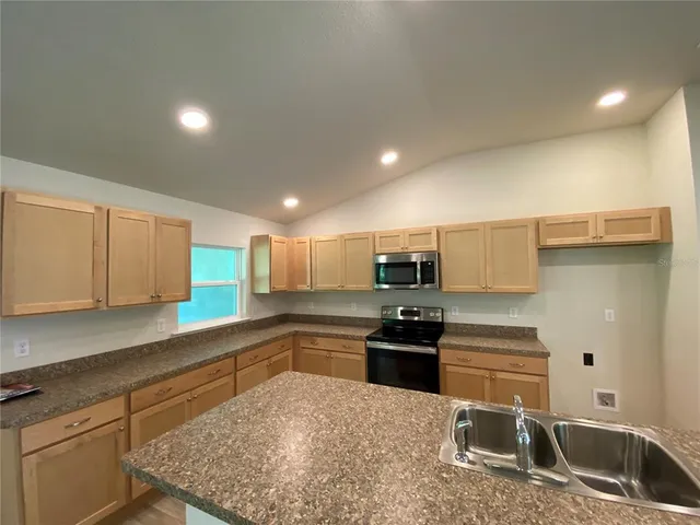 a kitchen with stainless steel appliances granite countertop a sink stove and refrigerator