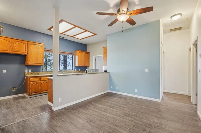 a large kitchen with a stove a sink dishwasher a refrigerator and a stove with wooden floor