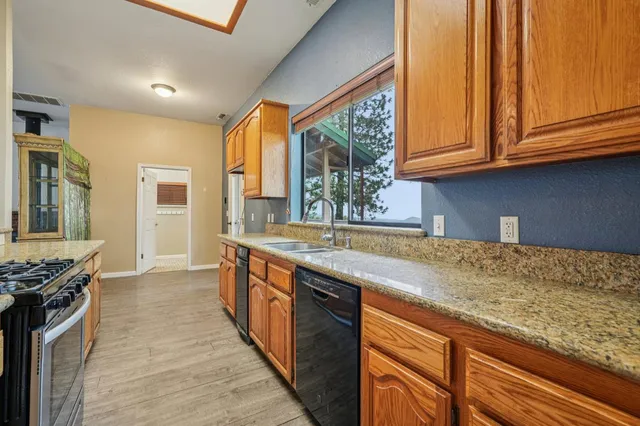 a kitchen with stainless steel appliances granite countertop a sink and a white cabinets