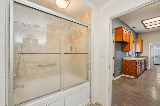 a hallway with cabinets a washer and dryer with wooden floor