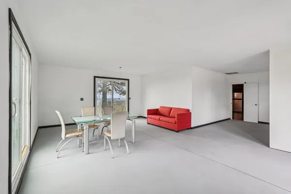 a view of a room that has a bed and a table in it