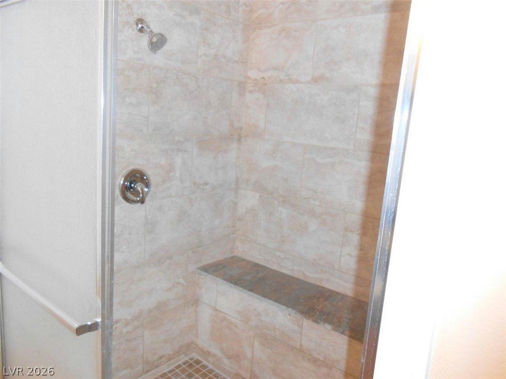 9325 West Desert Inn Road, Unit 132 Las Vegas, NV 89117 - Photo 11 of 36 A well-appointed shower space boasts neutral tiling and a convenient built-in bench.