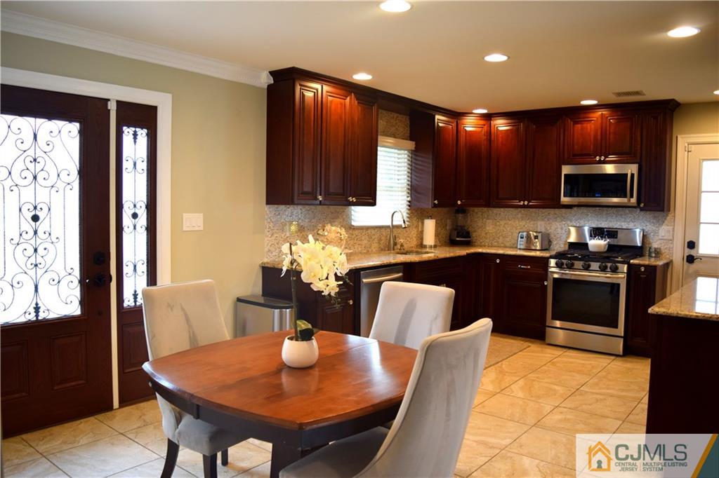 10 Fordham Road Old Bridge, NJ 08859 - Photo 5 of 26 a kitchen with stainless steel appliances kitchen island granite countertop a refrigerator a stove a sink a microwave and dining table