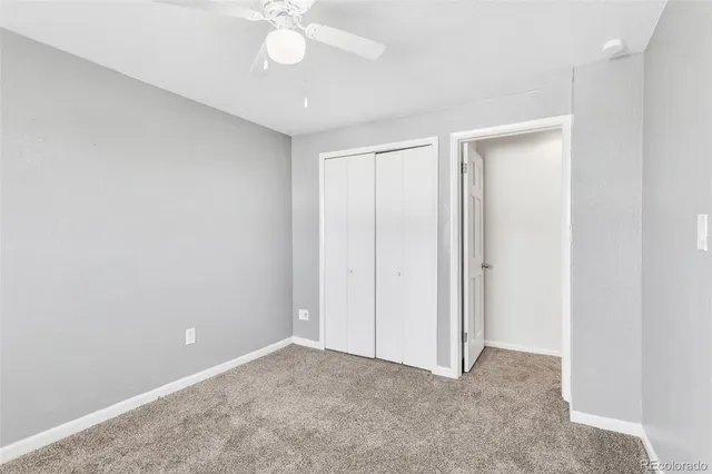 an empty room with a ceiling fan and a window