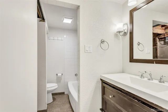 a bathroom with a granite countertop sink a toilet and a mirror