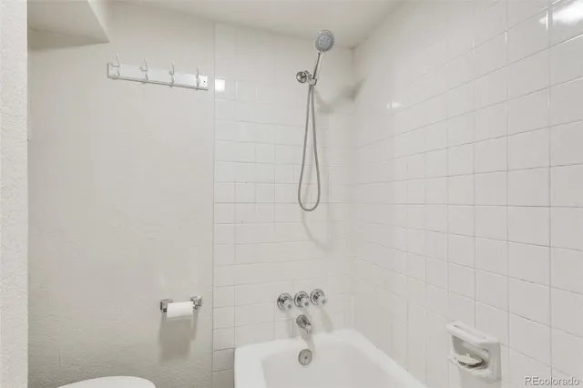a bathroom with a shower and a white bath tub