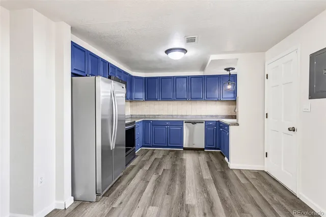 a kitchen with a refrigerator and wooden cabinets