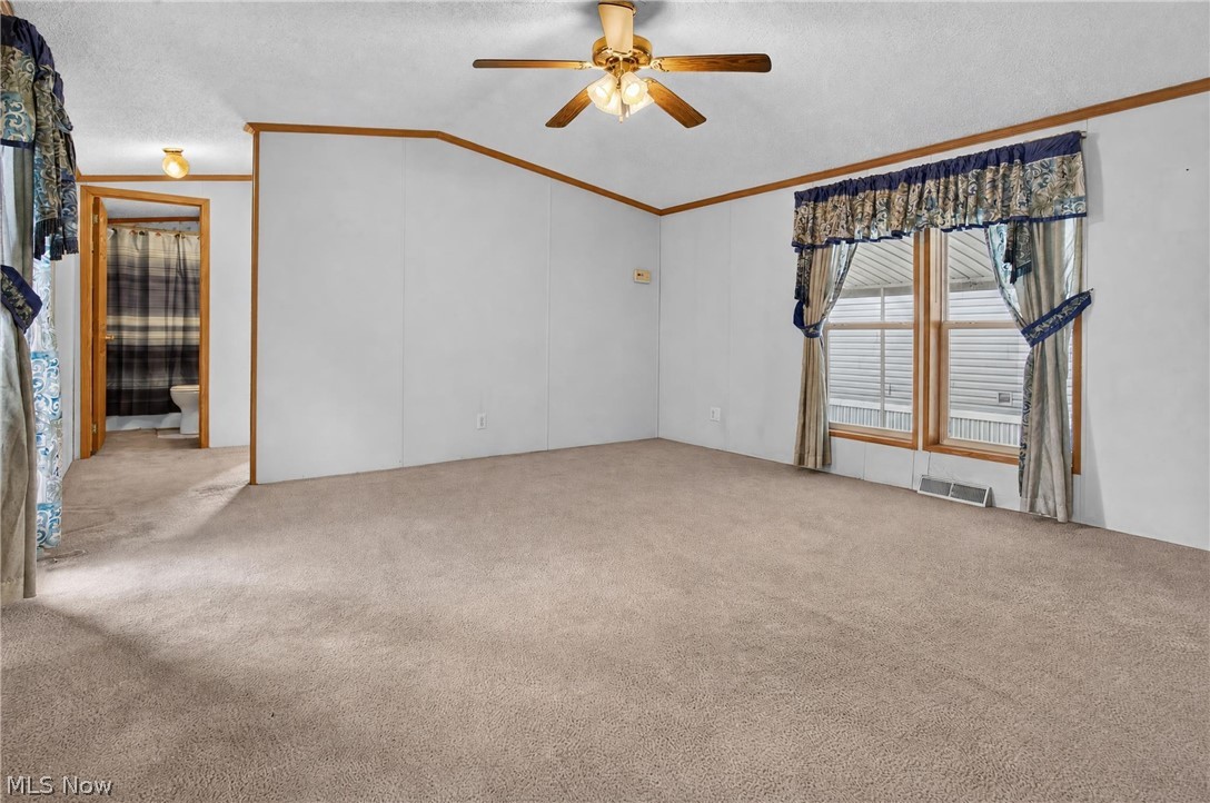 35157 Center Ridge Road, Unit 153 North Ridgeville, OH 44039 - Photo 8 of 35 Expansive carpeting throughout with natural wood-finish trim, a ceiling fan fixture, and a window with blinds