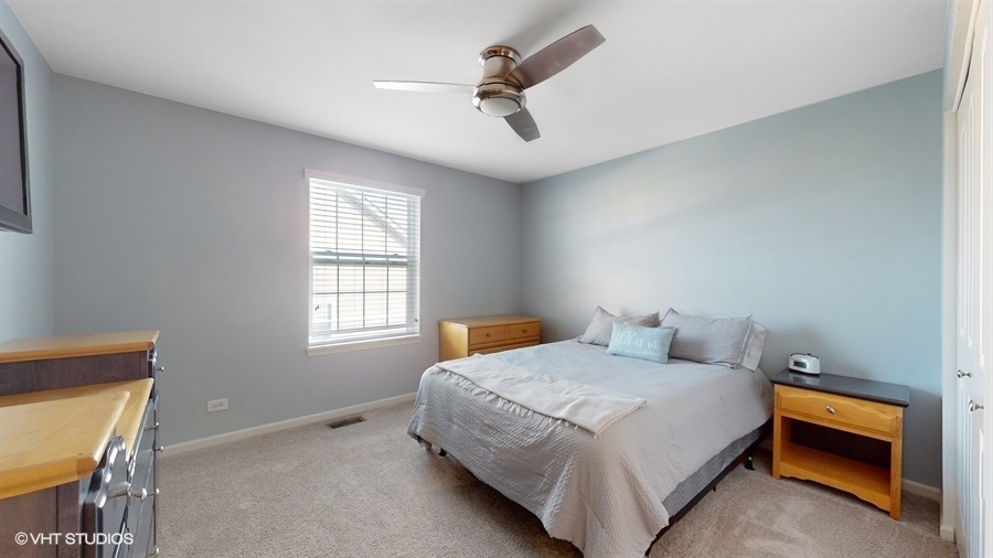 25613 West Cerena Circle Plainfield, IL 60586 - Photo 15 of 28 a bedroom with a bed and a chandelier