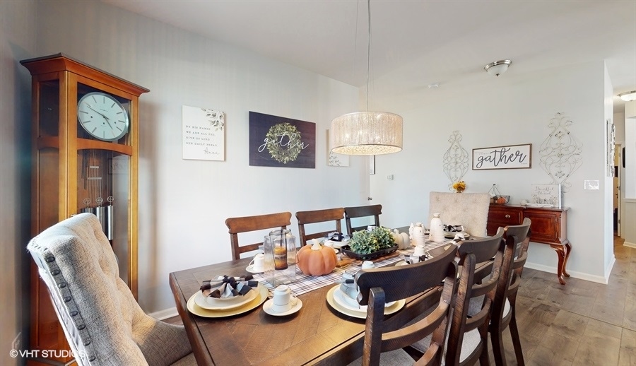 25613 West Cerena Circle Plainfield, IL 60586 - Photo 3 of 28 a view of a dining room with furniture a rug and wooden floor