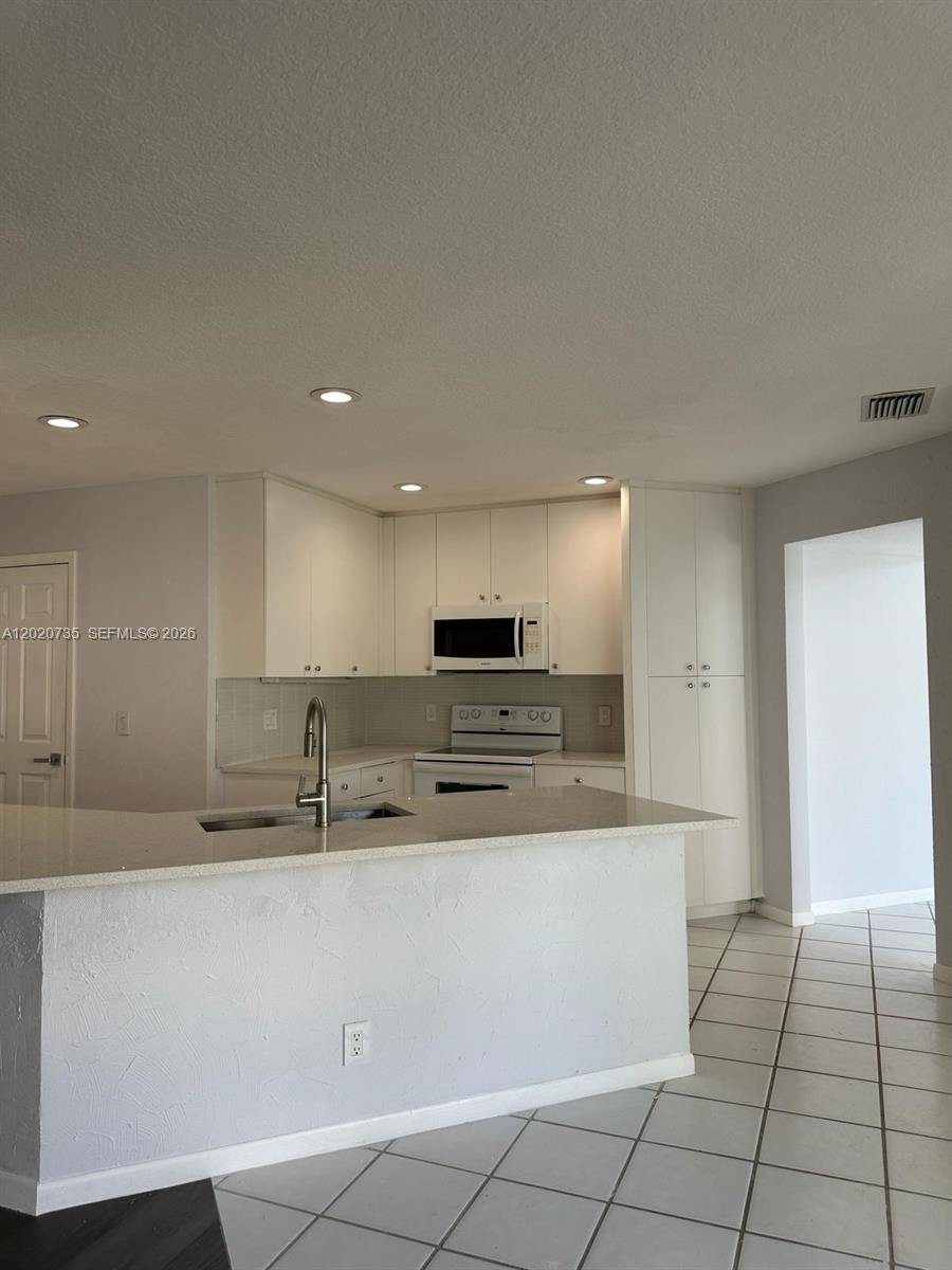 17244 Balboa Point Way Boca Raton, FL 33487 - Photo 12 of 66 a large kitchen with stainless steel appliances a sink and a stove top oven