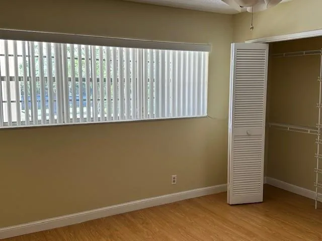 an empty room with wooden floor and a window
