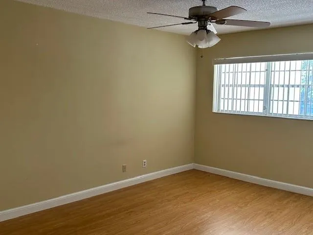 a view of a room with a window and a ceiling fan