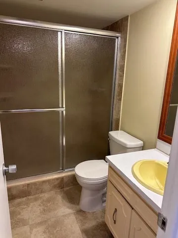 a bathroom with a granite countertop sink toilet and shower