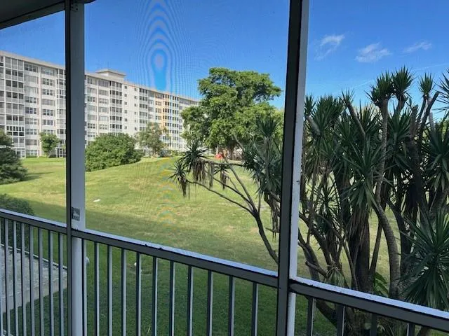 a view of a balcony with a yard