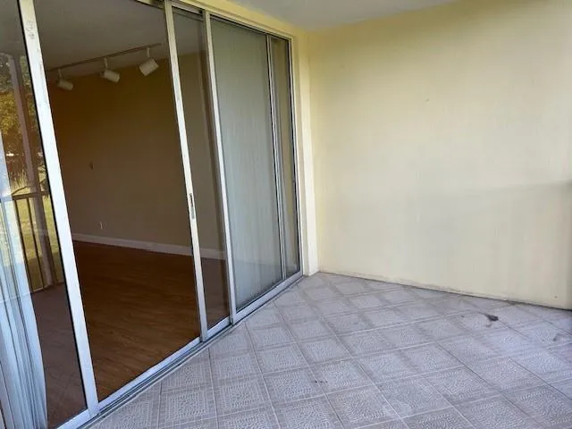 an empty room with sliding door and wooden floor