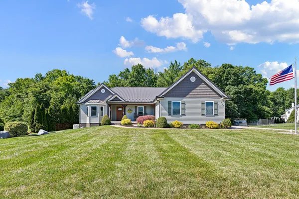 a front view of a house with a yard and trees