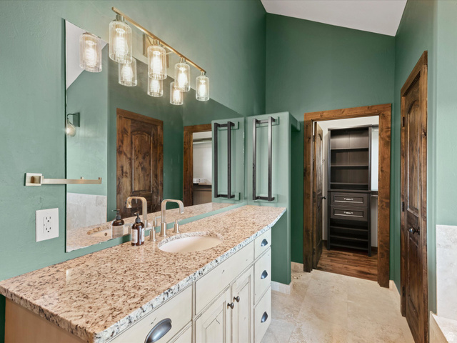 1225 Old Oregon Road Soda Springs, ID 83276 - Photo 37 of 67 Bathroom featuring an extended vanity with a built-in sink, granite countertop, and distressed cream cabinetry with dark hardware