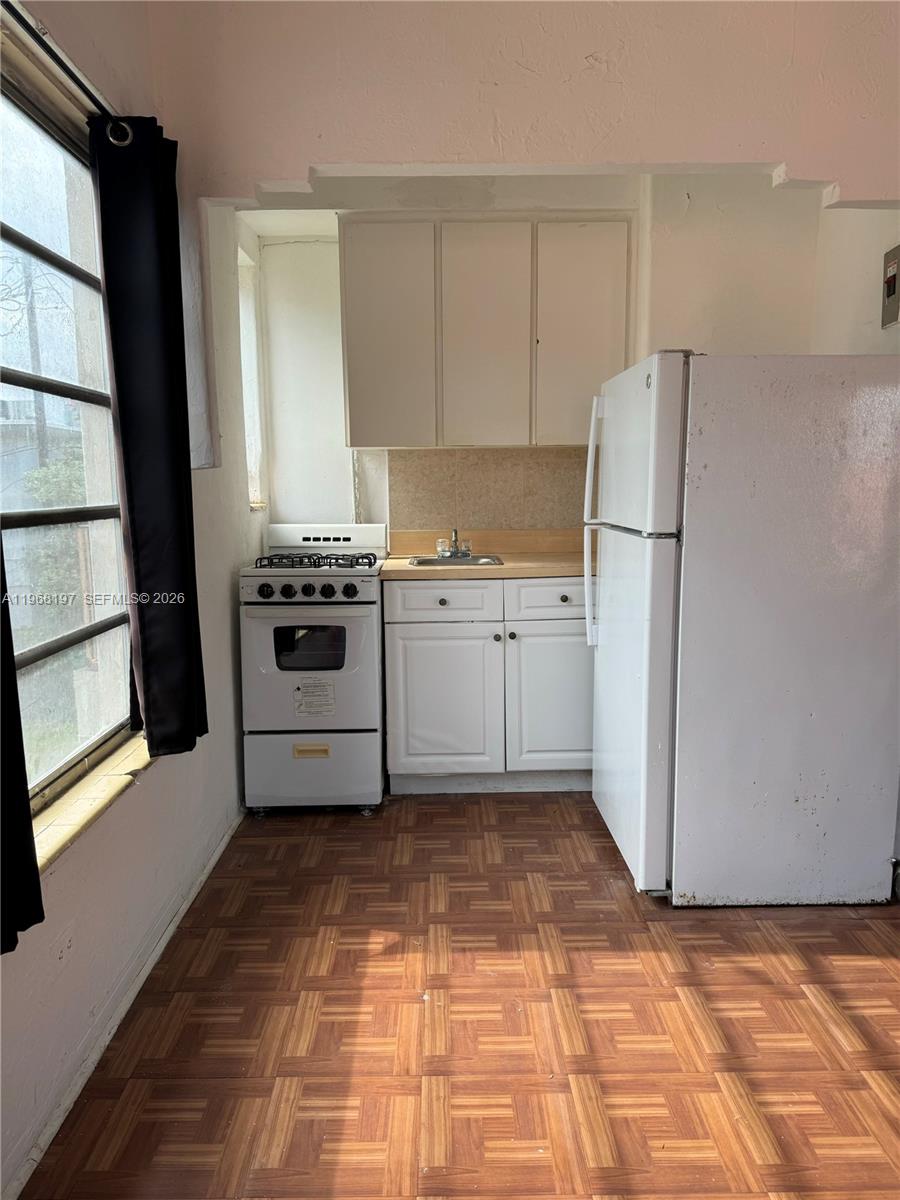 825 Alton Road, Unit 8 Miami Beach, FL 33139 - Photo 2 of 11 a kitchen with a stove a refrigerator and a sink
