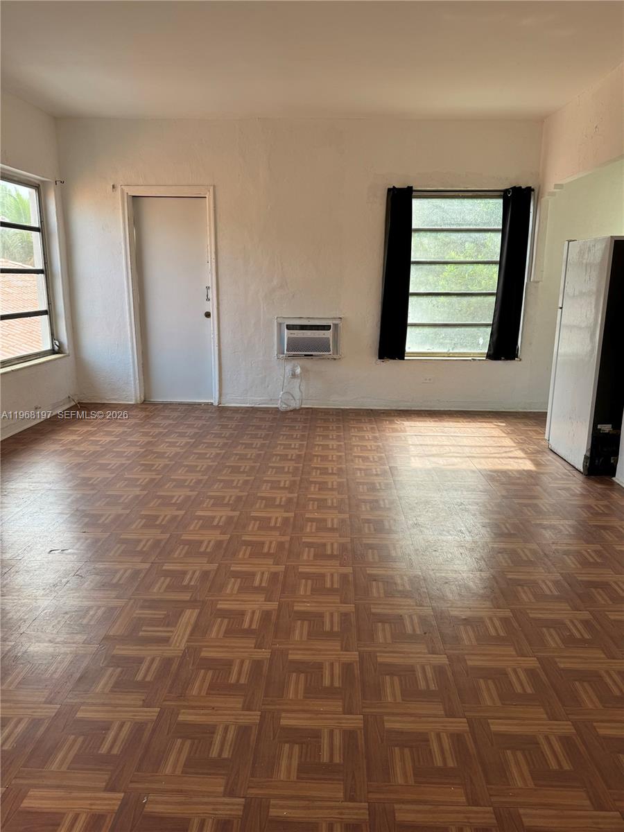 825 Alton Road, Unit 8 Miami Beach, FL 33139 - Photo 7 of 11 a view of an empty room with window and wooden floor