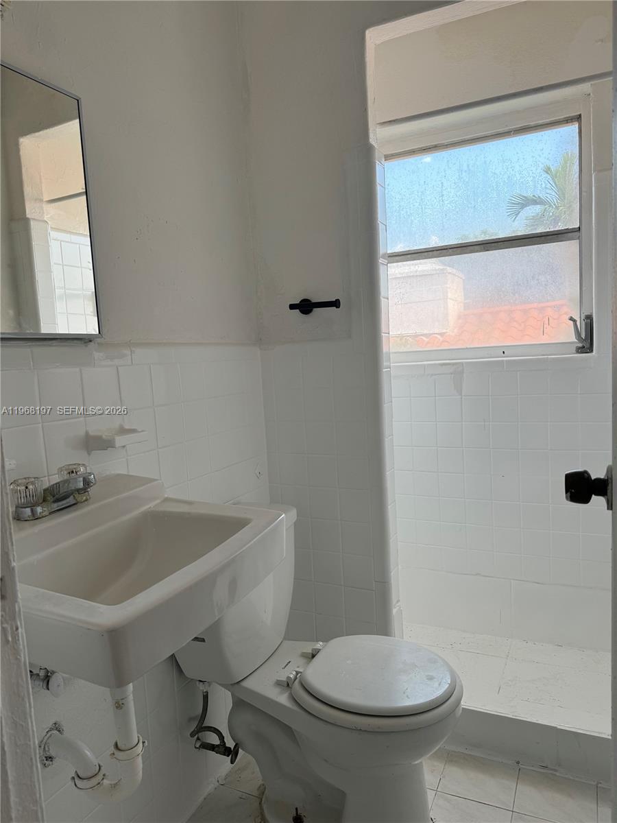 825 Alton Road, Unit 8 Miami Beach, FL 33139 - Photo 8 of 11 a bathroom with a sink a toilet and shower