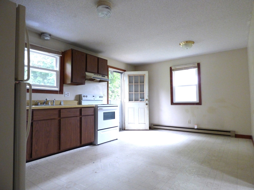 16-18 Daniel Street Springfield, MA 01151 - Photo 3 of 14 a kitchen with granite countertop a stove a sink and a refrigerator