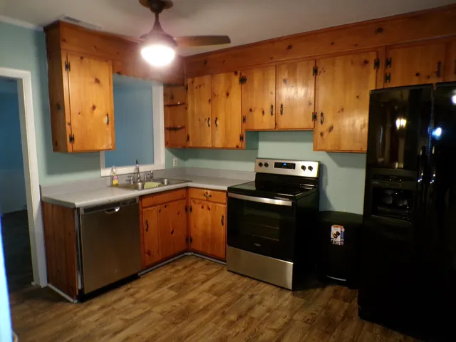 a kitchen with granite countertop stainless steel appliances and wooden cabinets