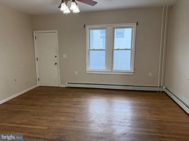 a view of a room with wooden floor and cabinet
