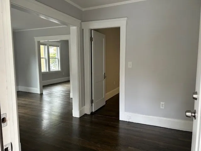 a view of a hallway with hardwood floor and a window