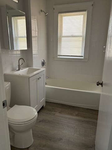 84 Aberdeen Avenue, Unit 1 Cambridge, MA 02138 - Photo 10 of 17 a bathroom with a toilet a sink a mirror and a window