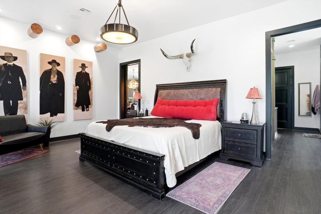 180 East Greer Road Sadler, TX 76264 - Photo 15 of 40 a spacious bedroom with a bed a dresser and wooden floor