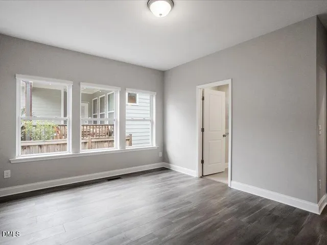 a view of an empty room with wooden floor