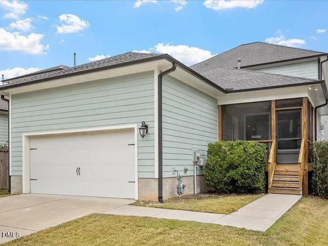 a view of yellow house with swimming pool and a yard