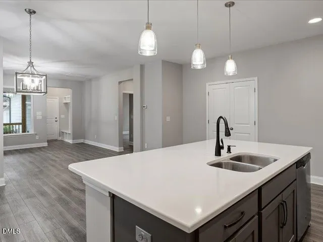 a kitchen with stainless steel appliances granite countertop a sink a stove and a wooden floors