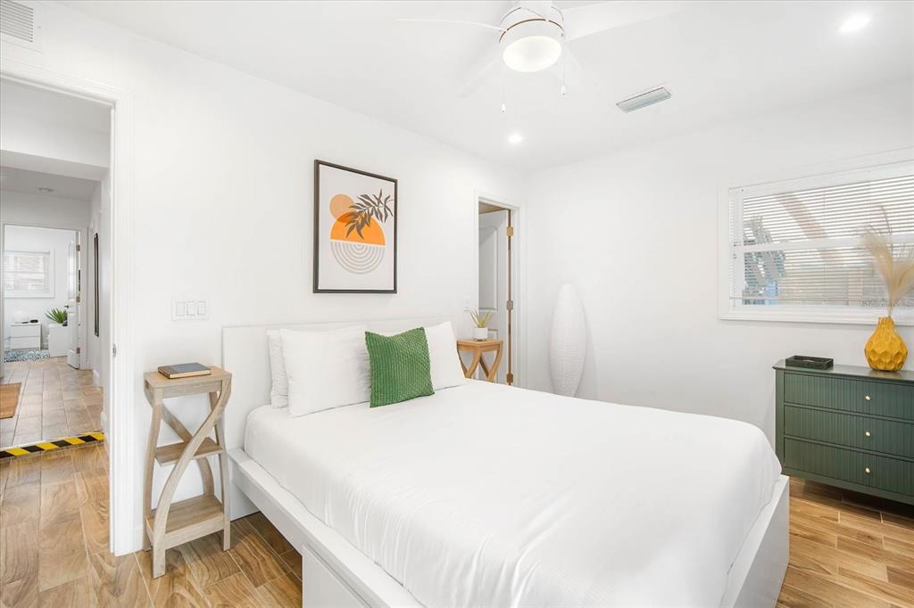 203 72nd Street Holmes Beach, FL 34217 - Photo 11 of 75 a bedroom with a bed and wooden floor